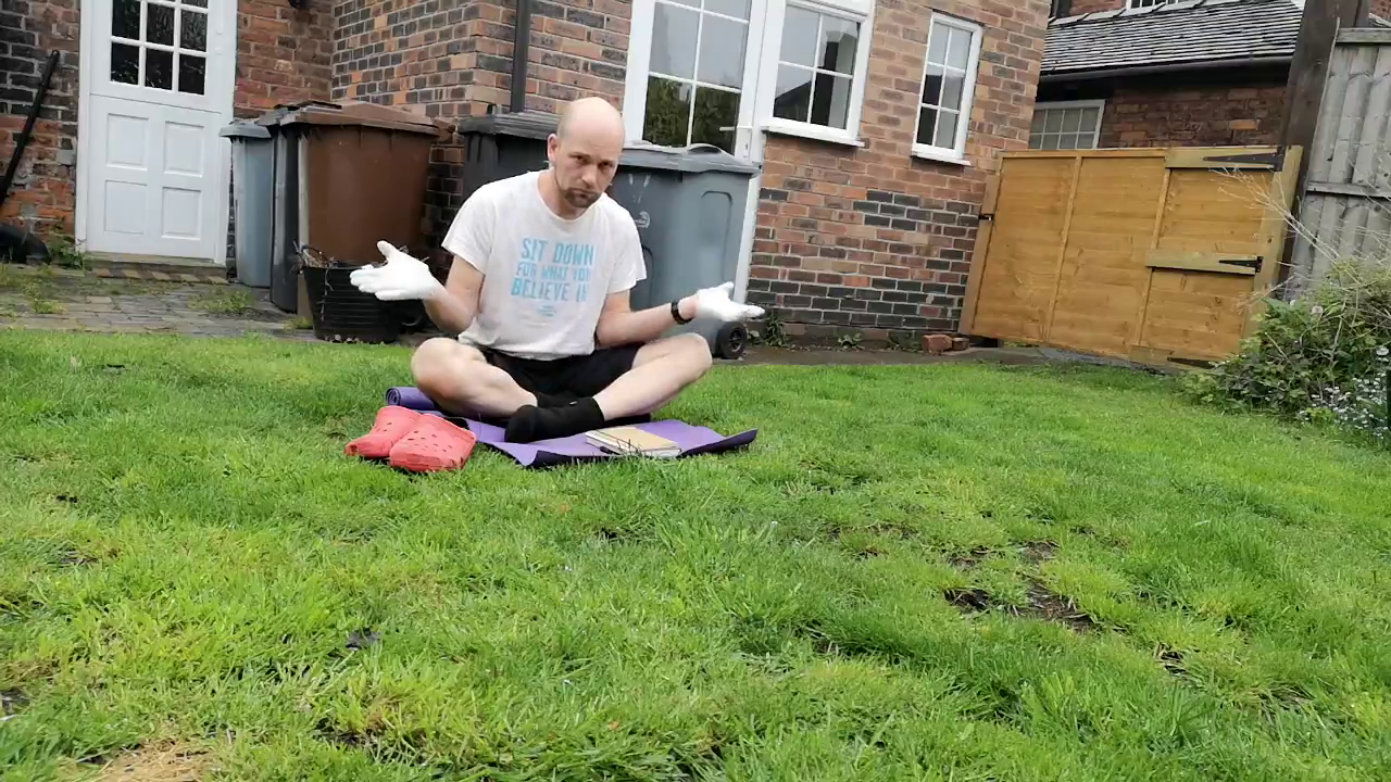 Craig Lambie sitting in an English garden in shorts and t-shirt